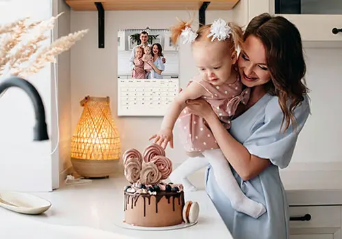 Familie feiert Geburtstag in der Küche, im Hintergrund ein Kalender mit Terminkalendarium