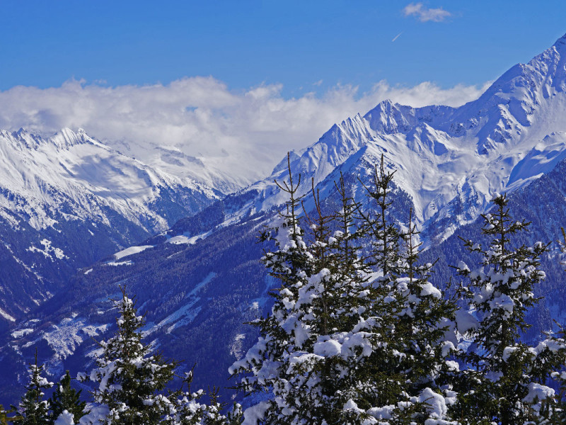 Blick auf Alpengipfel im Winter mit tiefhängenden Wolken